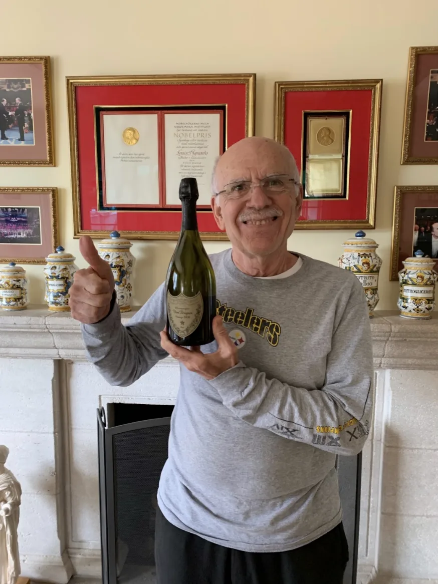 Dr. Lou Ignarro celebrating with champagne in the Nobel Room in Stockholm